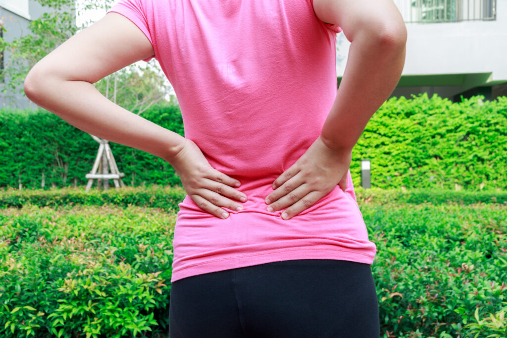 Female athlete lower back painful injury. Sporty woman backache